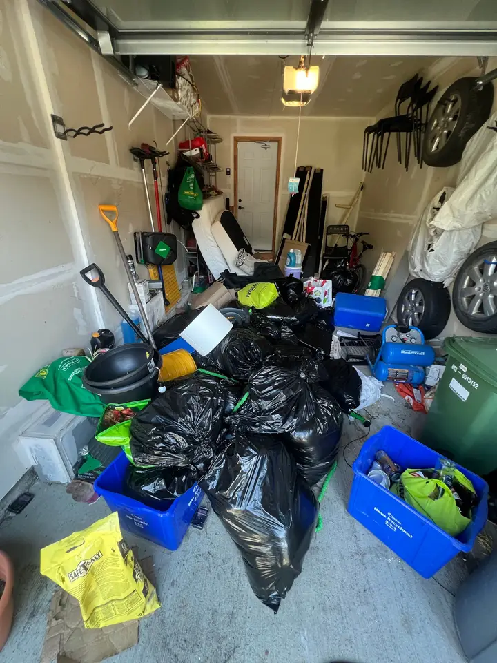 A garage filled with full garbage bags and household items